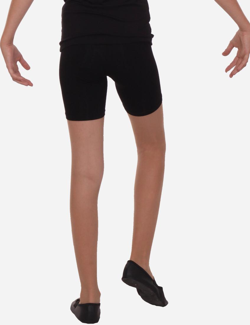 Youth black mid-length shorts paired with black ballet flats, presented in a dynamic dance stance for a clear view of the garment.