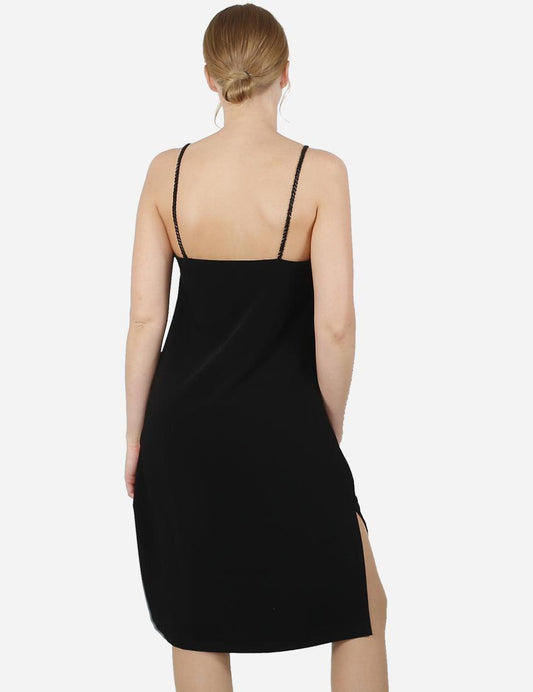 Back view of an exclusive black dress with delicate beaded straps on a woman.