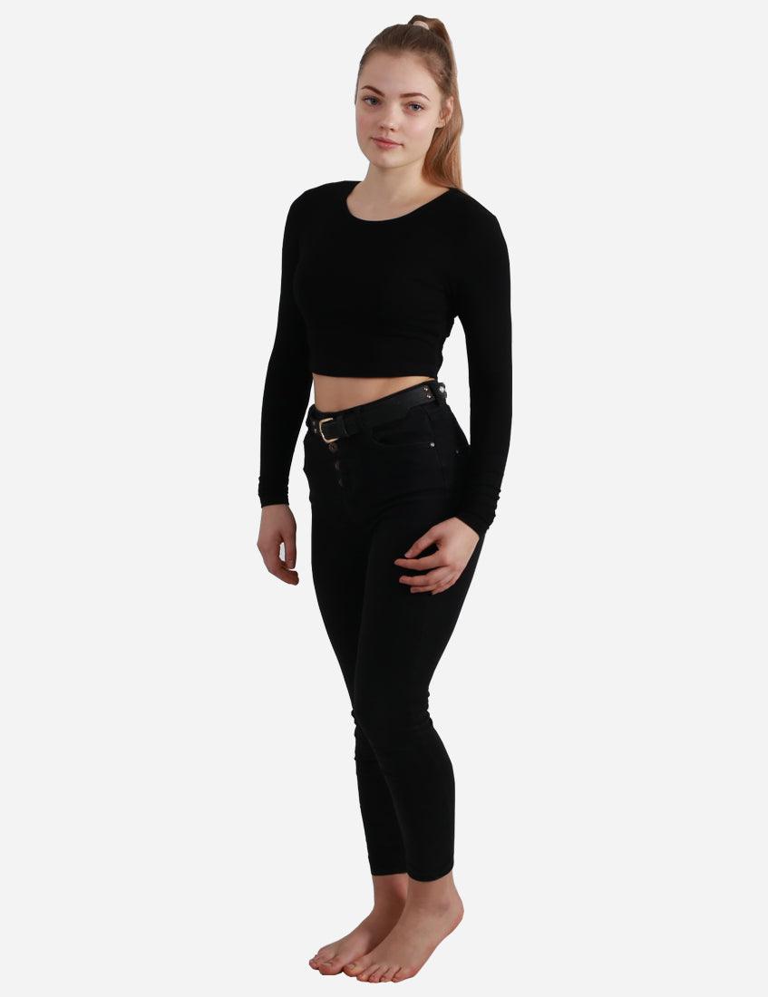 Full body side view of a woman in black long sleeve crop top and jeans on white background