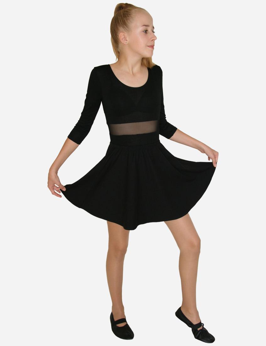 Full-length back view of a young girl wearing a black flared skirt with a transparent waist panel and ballet flats, isolated on white background.