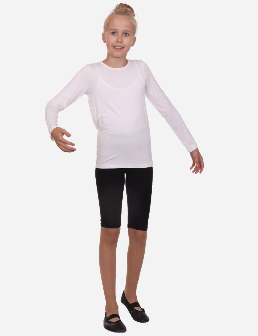 Young girl in white long sleeve top and black shorts with a side stance on white background