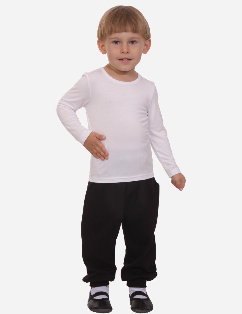 Confident little boy in white long sleeve shirt and black trousers posing with hand on hip on white background