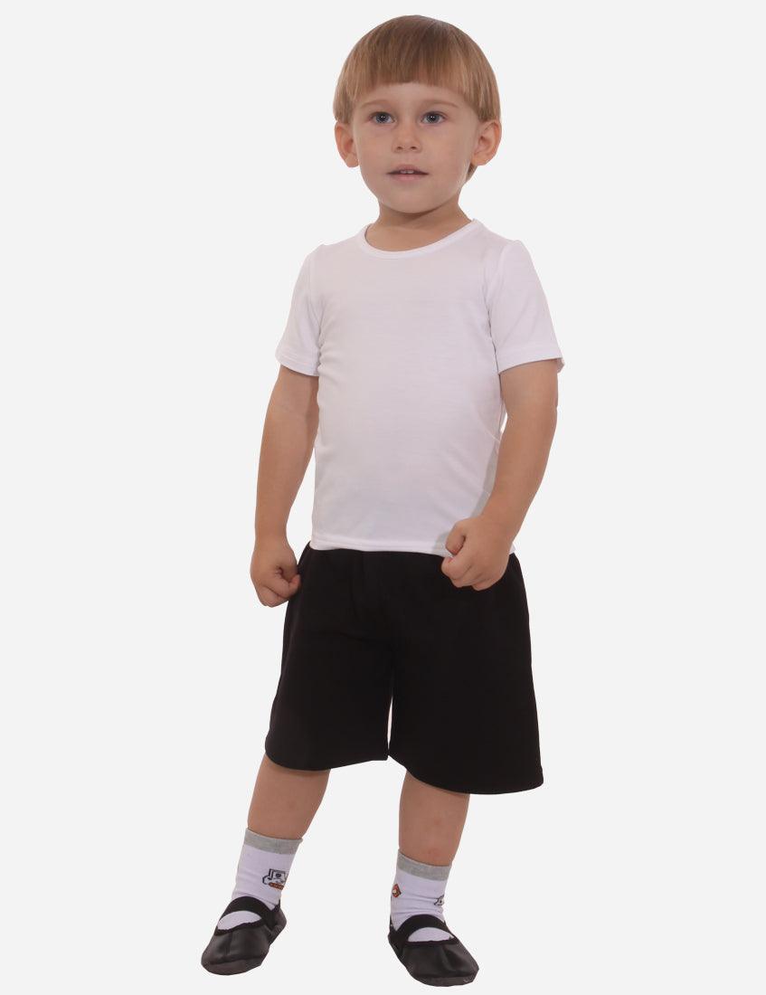 Young boy in light short-sleeved t-shirt and black shorts, standing straight, looking to the side, on a white background