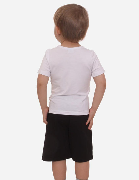 Back view of a boy in a light short-sleeved t-shirt and black shorts, standing on a white background