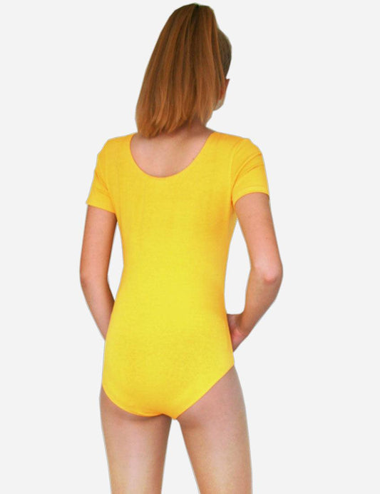 Back view of a young female gymnast wearing a yellow leotard with short sleeves on a white backdrop.