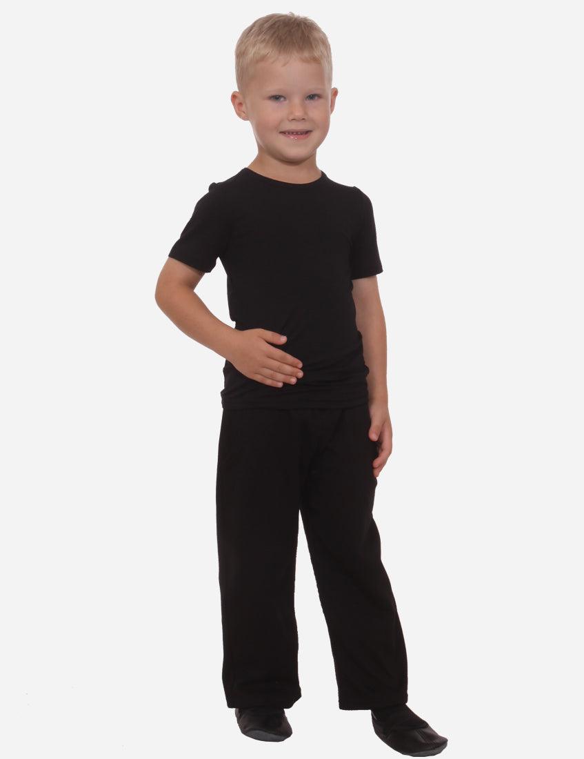 Smiling young boy in black t-shirt and black straight-leg pants standing front view on white background