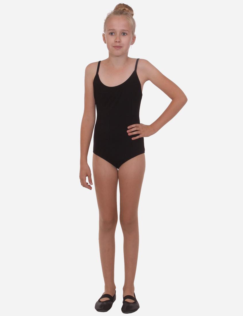 Full body shot of a young girl in a black leotard with straps, standing upright with ballet shoes, looking forward.