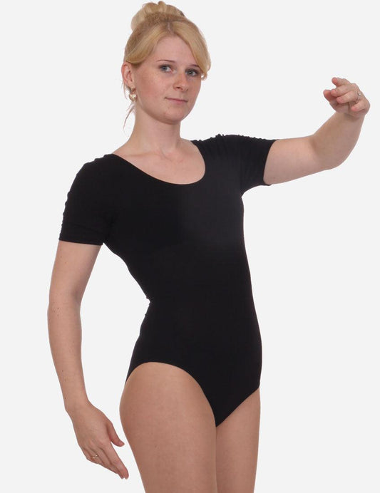 Elegant woman presenting a pose in a classic black leotard with short sleeves, paired with black ballet slippers.