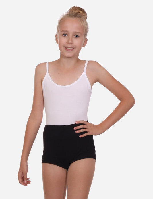 Confident young girl in white tank top and black shorts standing with hand on hip, white background